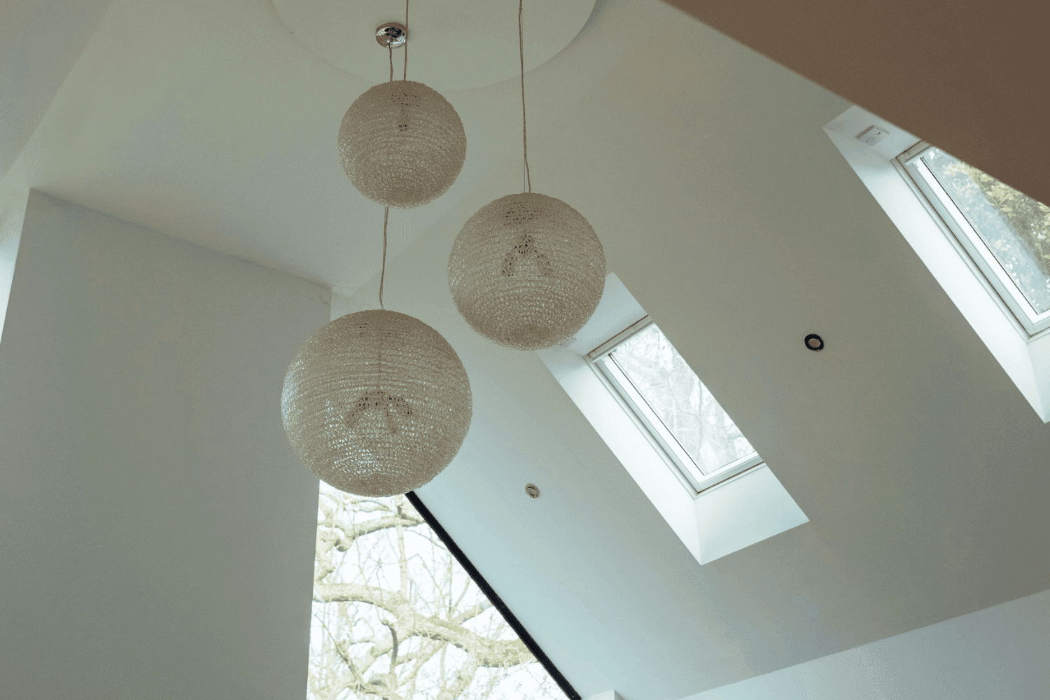 Kent home interiors featuring woven pendant lighting in a double-height contemporary living space